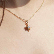 Gold necklace with a star-shaped pendant worn by a person